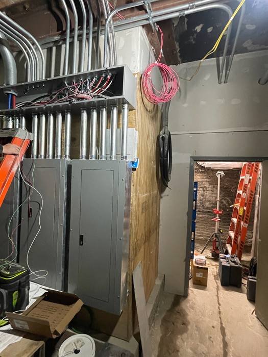 Overhead conduit rack feeding commercial electrical equipment and panels