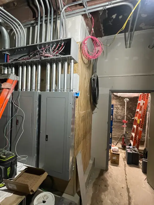 Overhead conduit rack feeding commercial electrical equipment and panels