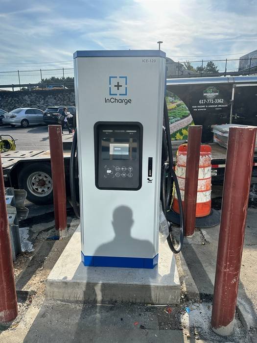 Commercial electric vehicle charger installed and energized in a parking area