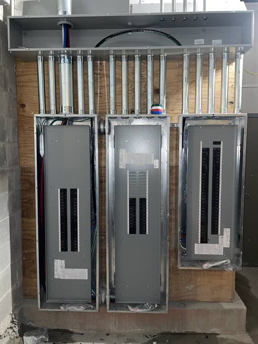 Commercial electrical panelboards installed side by side in a mechanical room