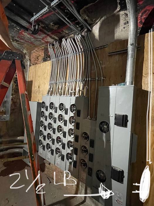 Electrical meter bank with conduit runs feeding a multi-unit service