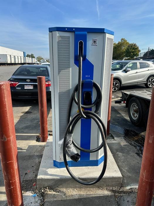 Electric vehicle fast charging station installed on a concrete pad with protective bollards