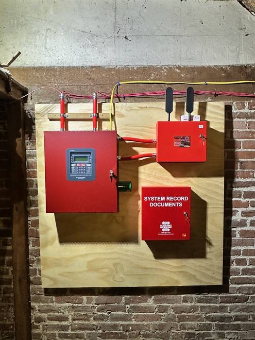 Fire alarm control panel and communicator mounted on a plywood backboard