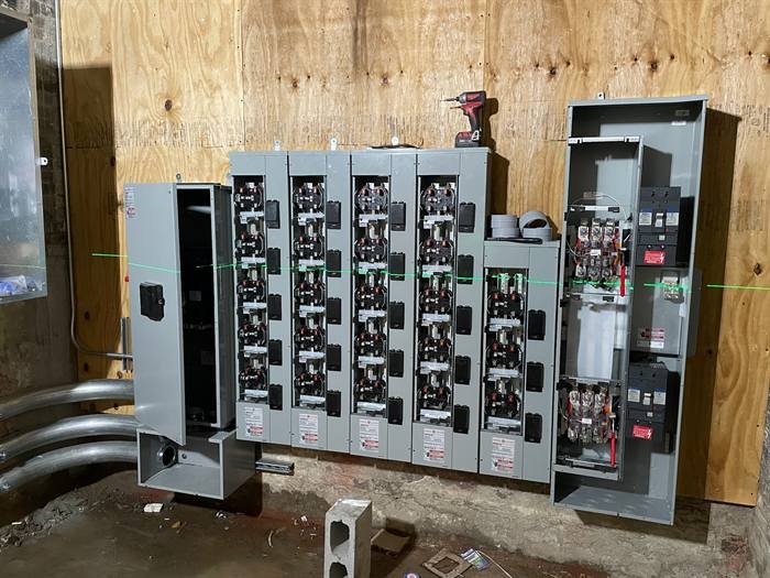 Multi-meter and electrical panel assembly mounted on plywood backing
